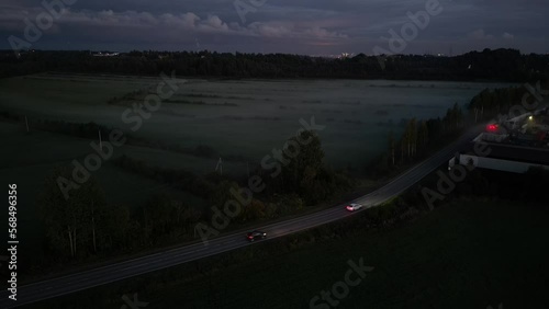 A car driving down a street at night. Drone view