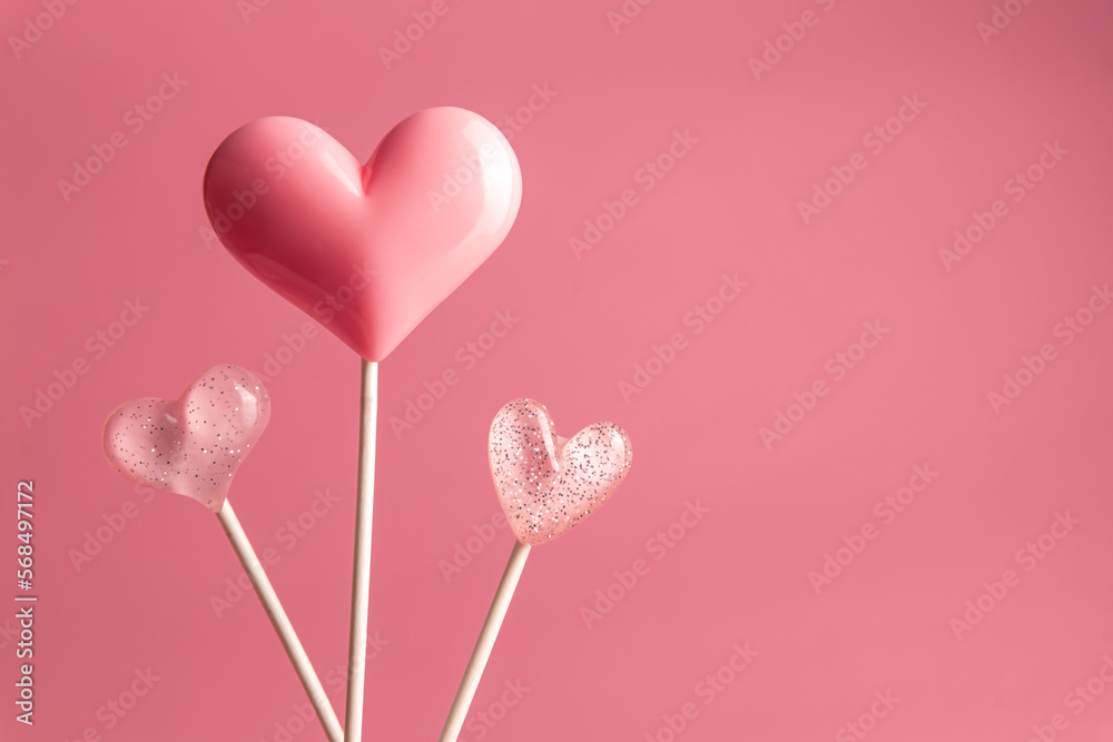 three viva magenta Valentine's day heart shape lollipop candy on empty pastel pink background. Love Concept. Minimalism colorful style. with copy space