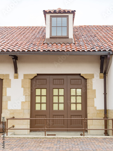 Stucco building with tile roof and window photo