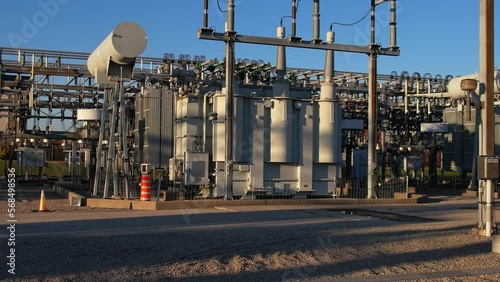 High voltage substation with pylons and distribution cables. Transformation station and electric power grid to vital industries, city households and EV charging stations. Inspection and development.