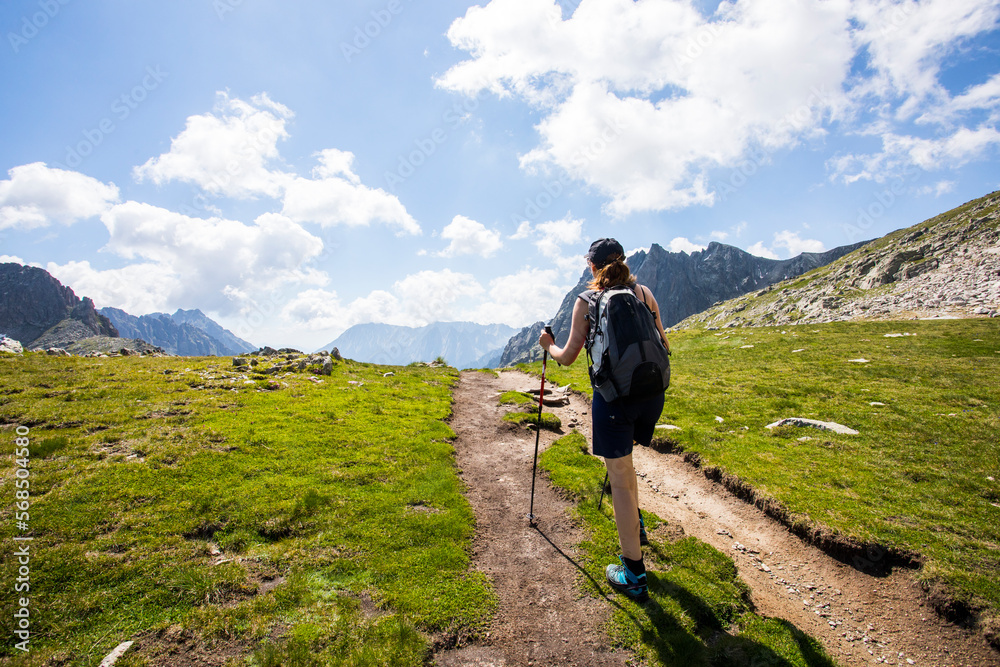 Fototapeta premium Young hiker girl summit to Ratera Peak in Aiguestortes and Sant Maurici National Park, Spain