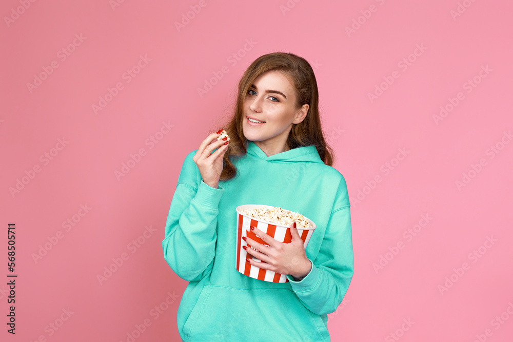 woman in sweatshirt watching movie film, eating popcorn woman in sweatshirt watching movie film, eating popcorn