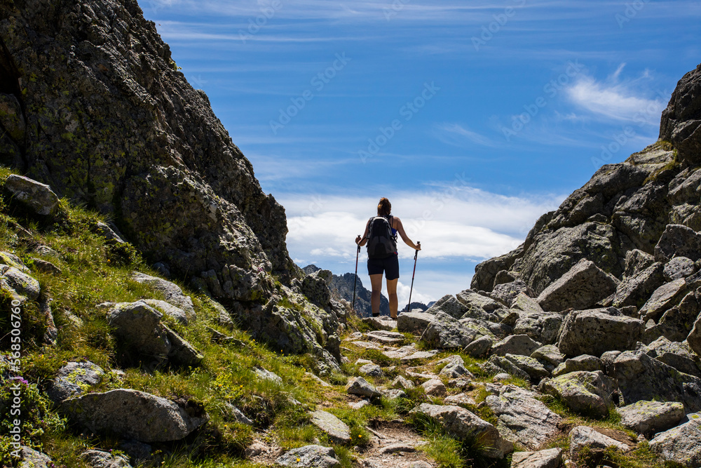 Obraz premium Young hiker girl summit to Montardo Peak in AIguestortes and Sant Maurici National Park, Spain