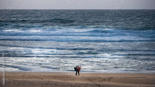 pilgrim couple embracing at the Atlantic Ocean in Finisterre at the end of the Camino de Santiago photo