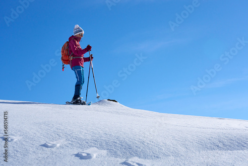 nice and active senior woman snowshoeing in deep powder snow in themountains of the Allgau alps near Balderschwang, Bavaria, Germany 