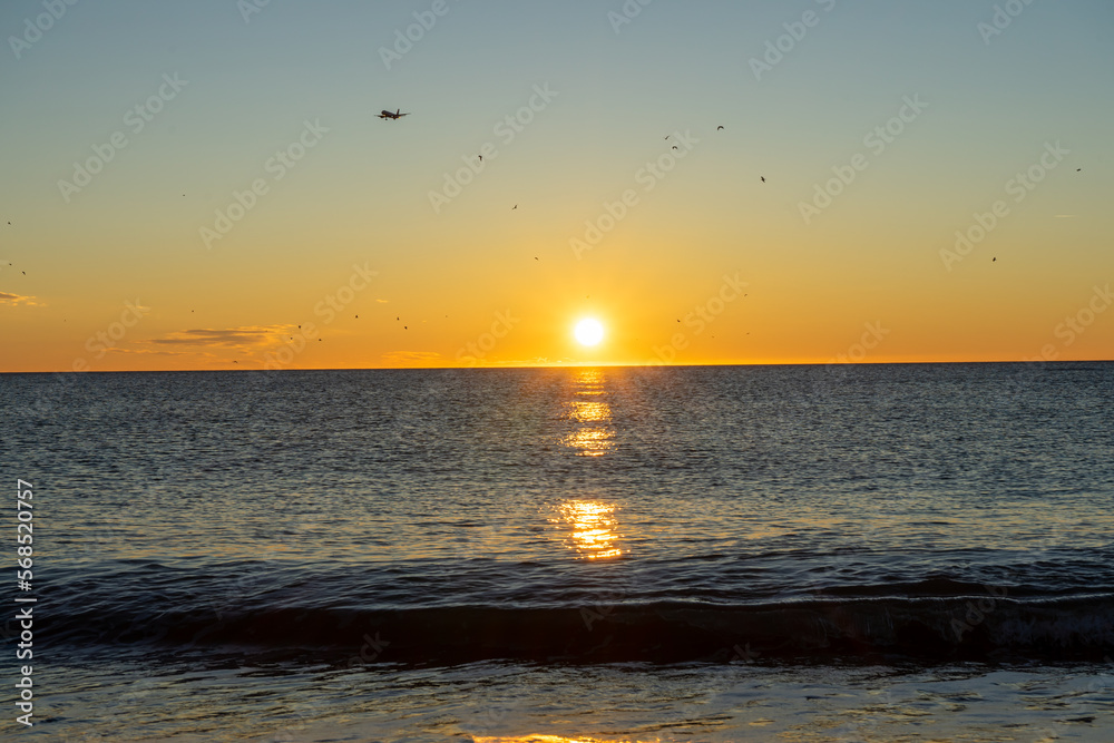 Airplane landing at sunrise over Mediterranean Sea, Costa del Sol, Malaga, Spain