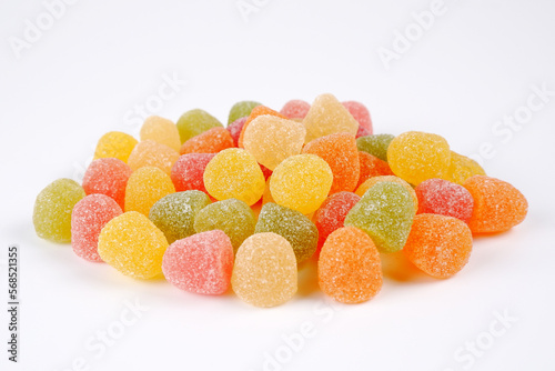 The background consists of many delicious sweet colored little marmalades on a white background.Fruit jelly. Jelly citrus candies in yellow, red, orange and green colors.Copyspace