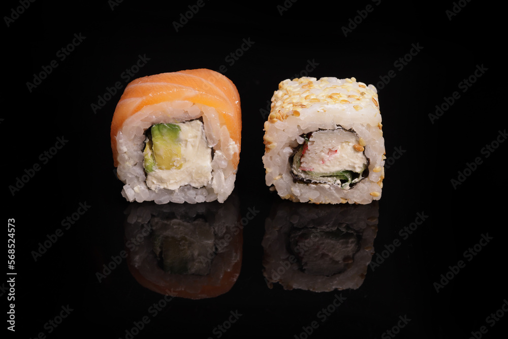 Various sushi with salmon, tuna, avocado, sesame on a mirror black surface Various sushi with salmon, tuna, avocado, sesame on a mirror black surface