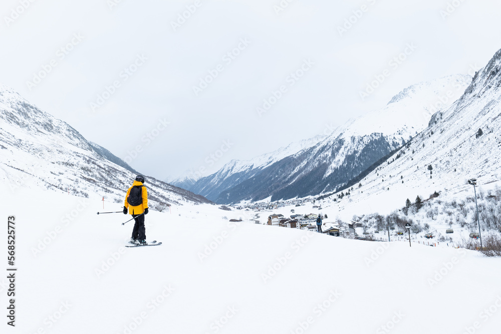 skier with a yellow jacket on the slope