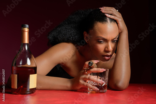 Young Black Woman Depressed Smoking a Cigar and Drinking Liquor