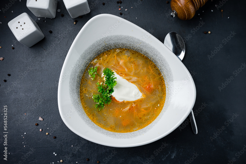 Obraz Soup with cabbage, potatoes, carrots, pork, greens and sour cream