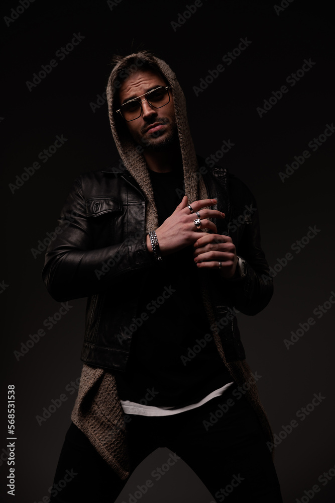 Obraz premium confident cool man with hoodie wearing leather jacket and wool cardigan
