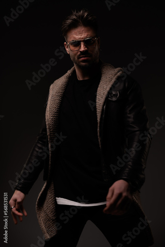 fashion stylish guy with cool hairstyle wearing wool cardigan and leather jacket