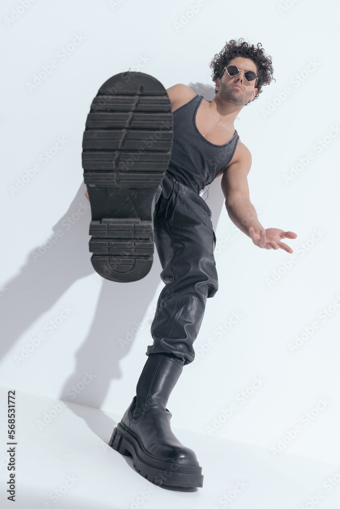 sexy muscle guy with curly hair in undershirt showing one boot sexy muscle guy with curly hair in undershirt showing one boot