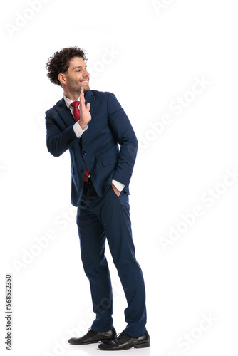 happy elegant businessman smiling and waving while looking behind