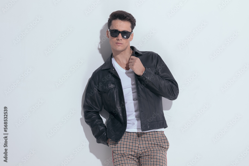 casual man arranging his collar, putting hand in pocket casual man arranging his collar, putting hand in pocket