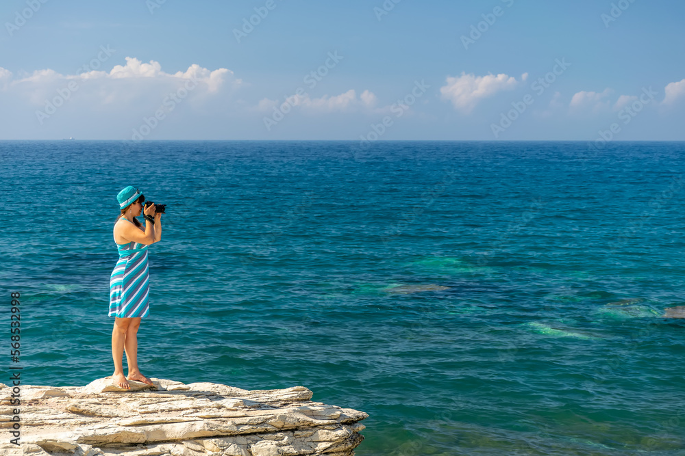 Obraz premium Girl photographer takes a picture of the sea