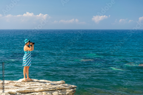 Girl photographer takes a picture of the sea