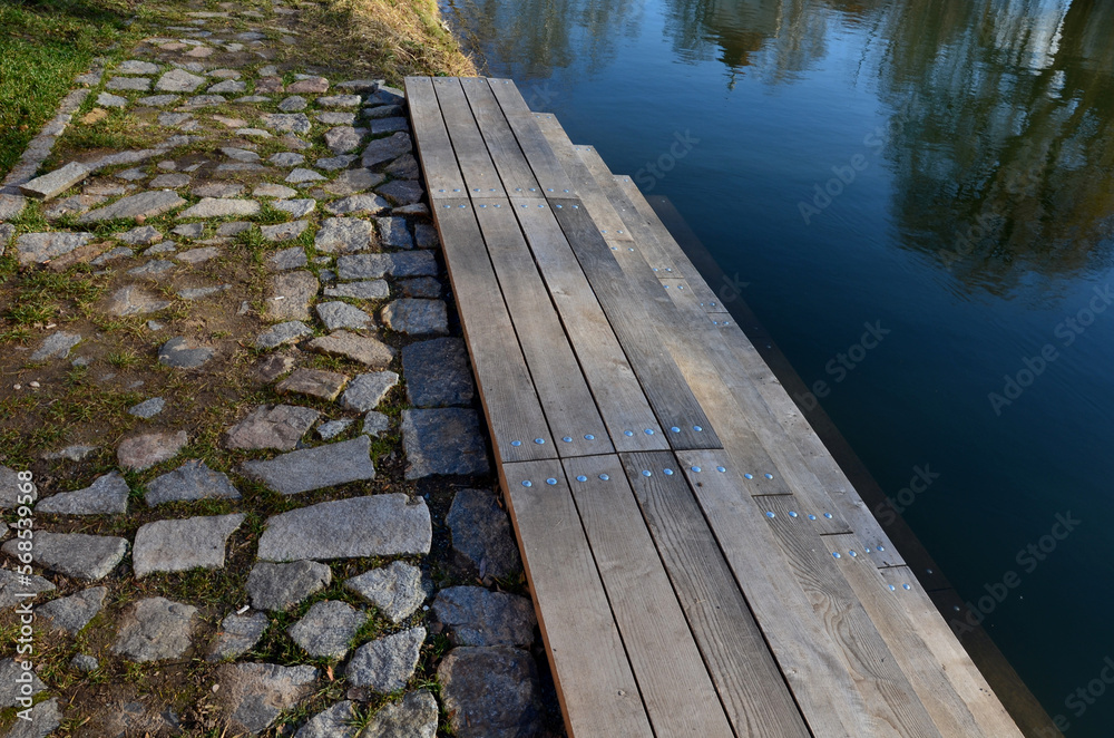 Obraz premium access to water after galvanized staircase construction. entrance for ice skaters in winter to the frozen pond. refreshment after sauna.stone slate, lawn, seat, sit, wide, natural pool resort, drone