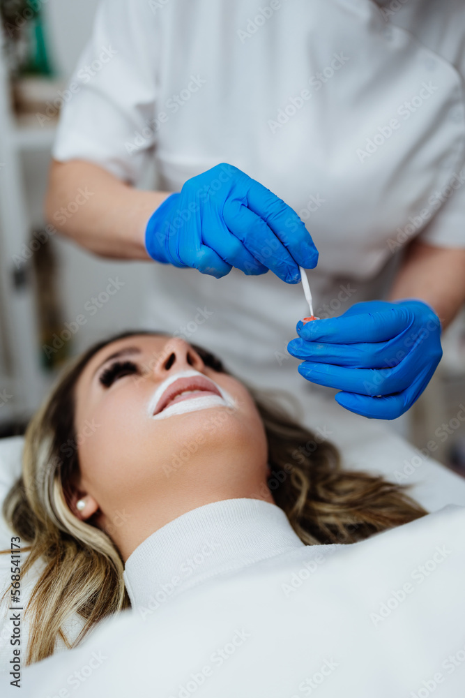 Fototapeta premium Professional permanent make up procedure. Tattoo lips makeup treatment in modern beauty salon.