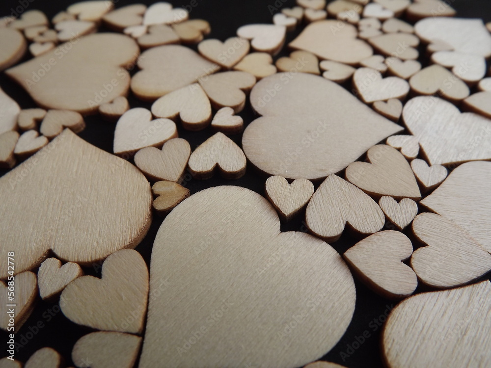 Obraz premium Wooden hearts on a black background as a postcard for the holidays