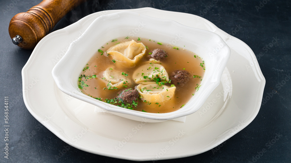 Dinner boiled Italian tortellini dumplings with meat in beef broth with greens. Dinner boiled Italian tortellini dumplings with meat in beef broth with greens.
