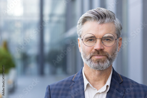 Wallpaper Mural Close-up portrait of serious focused businessman, mature man wearing glasses and business suit looking at camera from outside office building. Torontodigital.ca