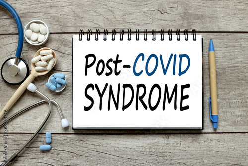 Medical concept. wooden background with notepad. text on paper. - Post covid syndrome photo