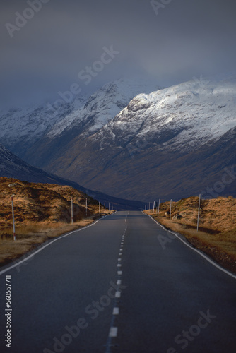 A road leading through the Scottish Highlands of Glen Coe to the snow-capped mountains. Scotland