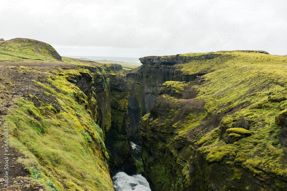 Beautiful landscape with land covered in green moss in Iceland on a cloudy day