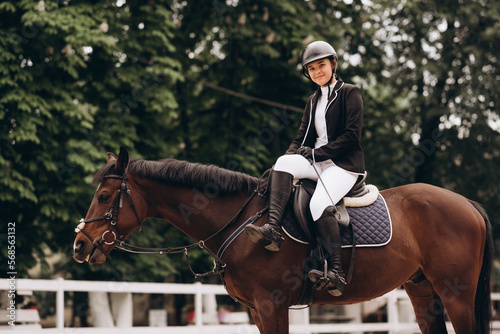 Equestrian sport - a young girl is riding a horse