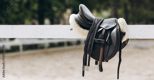 English saddle hanging on a wooden stable door