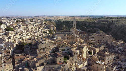 Aerial footage of Sassi di Matera in Basilicata, South Italy.Drone 360 orbit from Civita to Sasso Barisano district, old city houses carved in rock caves, stairs, bell tower of Cathedral from above