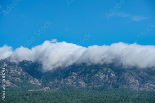 Corsica, mountains engulfed in clouds with blue sky