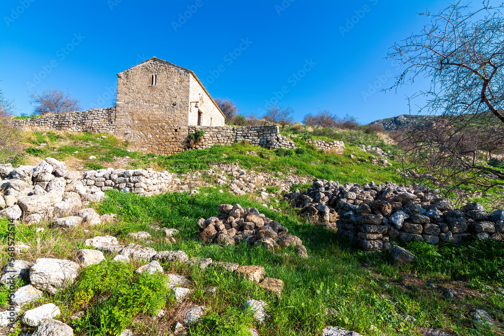 Stone church in the ruins of Acrocorinth fortress on a sunny day.