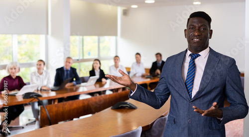 Wallpaper Mural Portrait of successful african american businessman in front of team of businessmen in a meeting room Torontodigital.ca