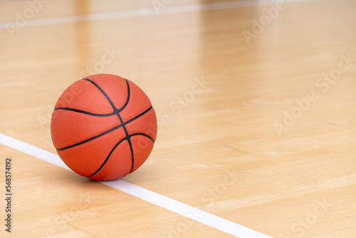 Orange basketball ball on hardwood court floor. Horizontal sport theme poster, greeting cards, headers, website and app © Augustas Cetkauskas