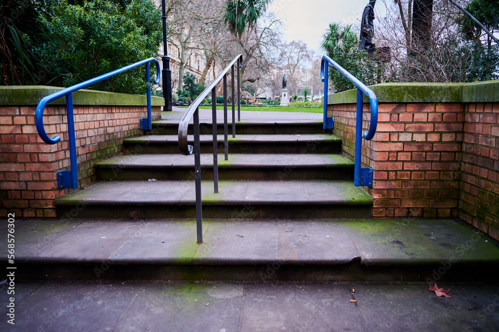 steps with metal railing and red brick wall to park steps with metal railing and red brick wall to park