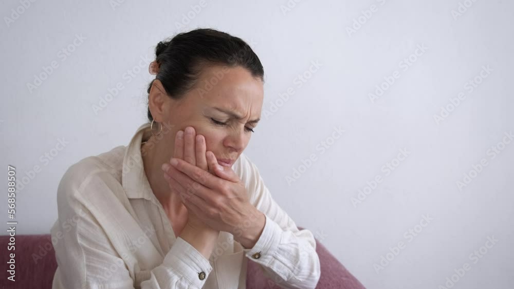 Alone female suffer from toothache. A view of unhappy woman with toothache attack in the room. A concept of woman suffering from pain in loneliness. Alone female suffer from toothache. A view of unhappy woman with toothache attack in the room. A concept of woman suffering from pain in loneliness.