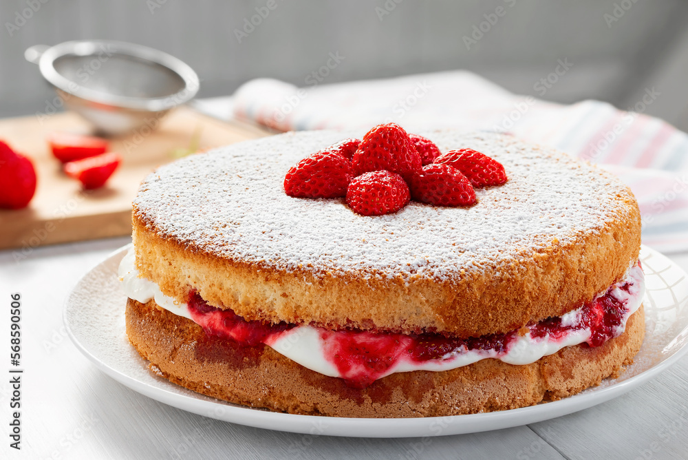 Two-layer Victoria cake with whipped cream, strawberry jam and fresh berries, closeup