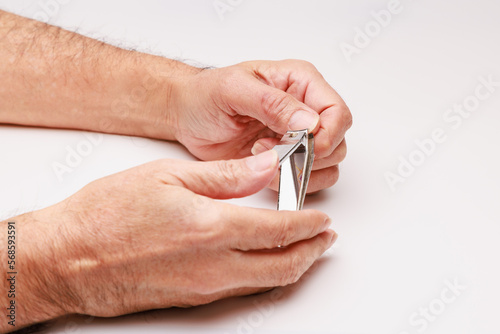テコ型爪切りで左手の爪を切る photo