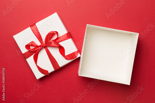 Open gift box on color background, top view
