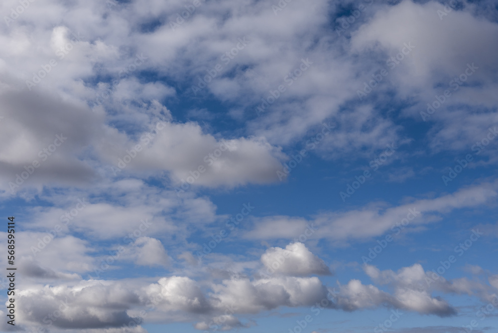 blue summer sky with white clouds blown by a strong wind forming beautiful patterns some fluffy low and others higher and open blue summer sky with white clouds blown by a strong wind forming beautiful patterns some fluffy low and others higher and open