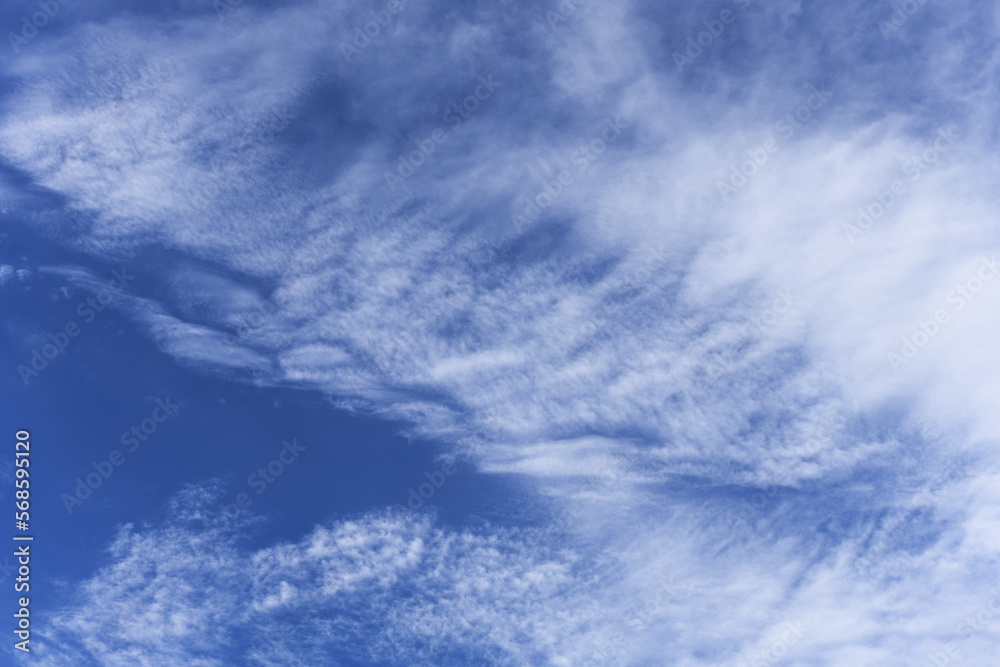 blue summer sky with white clouds stirred by strong wind