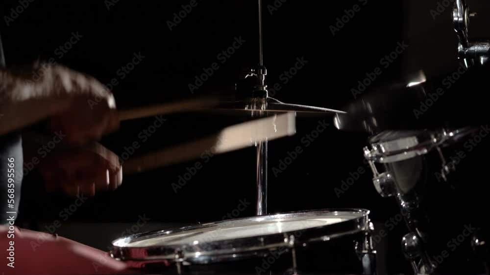 Hands of drummer musician man playing rhythmically hitting drum kit, side view.