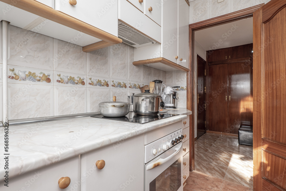 Small kitchen with new ceramic hob with pots on top to prepare food Small kitchen with new ceramic hob with pots on top to prepare food