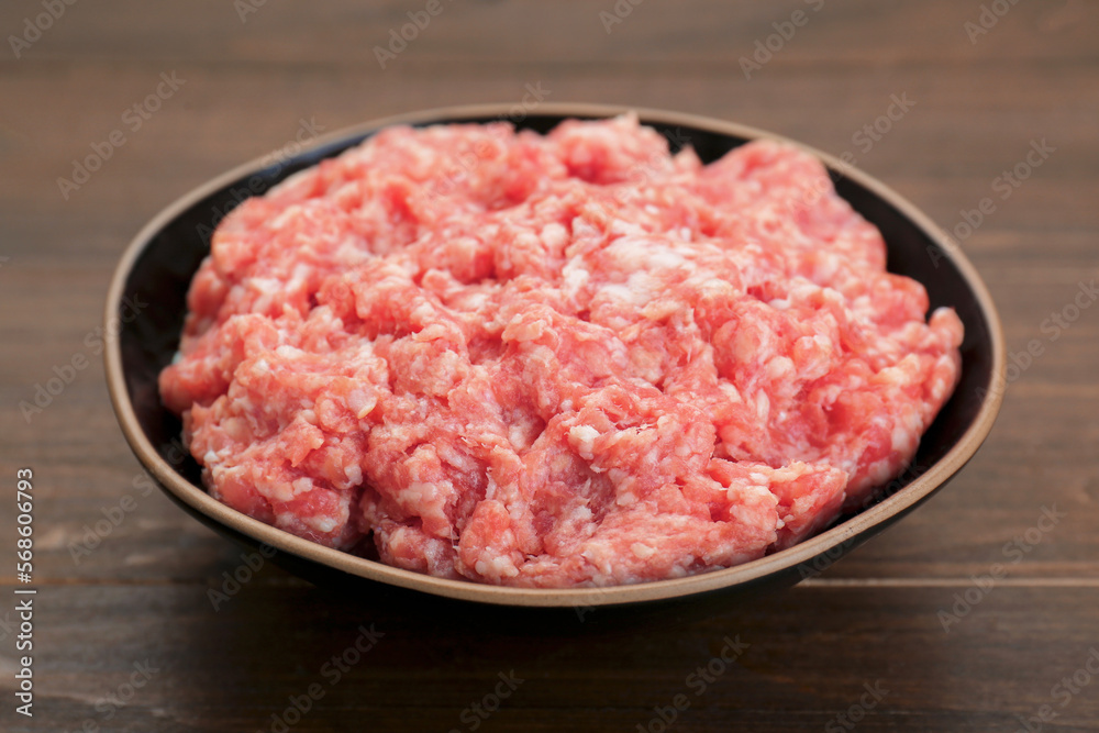 Bowl with raw fresh minced meat on wooden table, closeup Bowl with raw fresh minced meat on wooden table, closeup