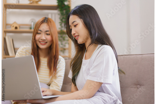 Activity at home concept, LGBT lesbian couple read and typing data on laptop while working together