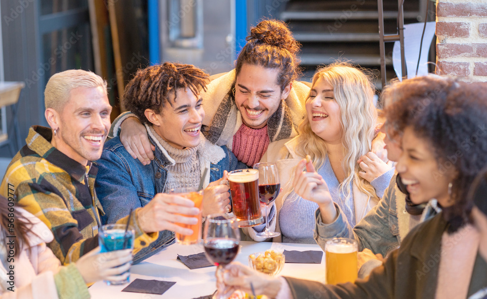 Group of happy friends are drinking beer and cocktail together . Young people student multiracial toast smiling with wine in lifestyle friendship in a pub party