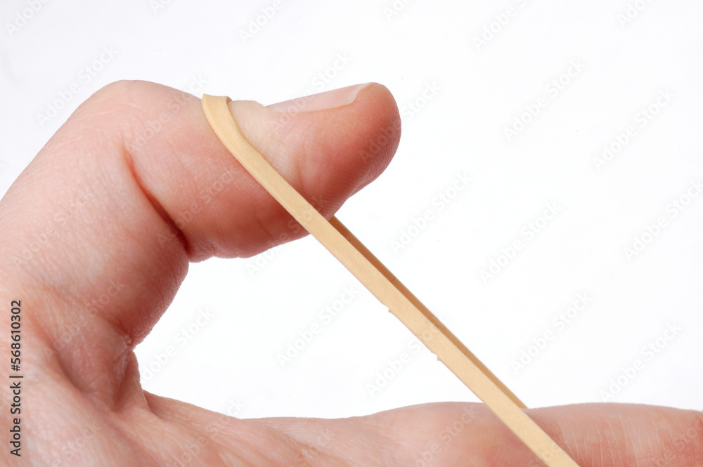Thumb pulling a rubberband taut. Tension, flexibility and other concepts Thumb pulling a rubberband taut. Tension, flexibility and other concepts